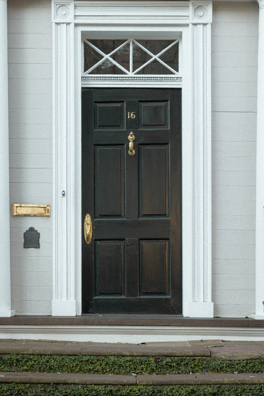 Black front door on a light-coloured home