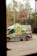 A vibrant van wrapped in colorful branding driving through a busy street.