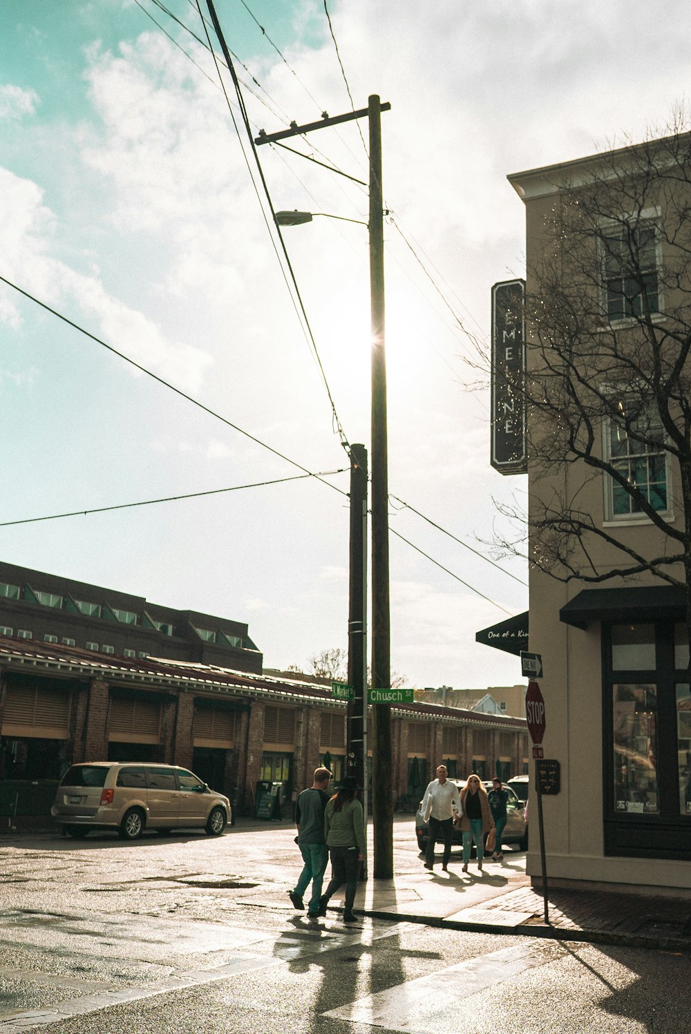 a group of people walking down a street next to a tall building