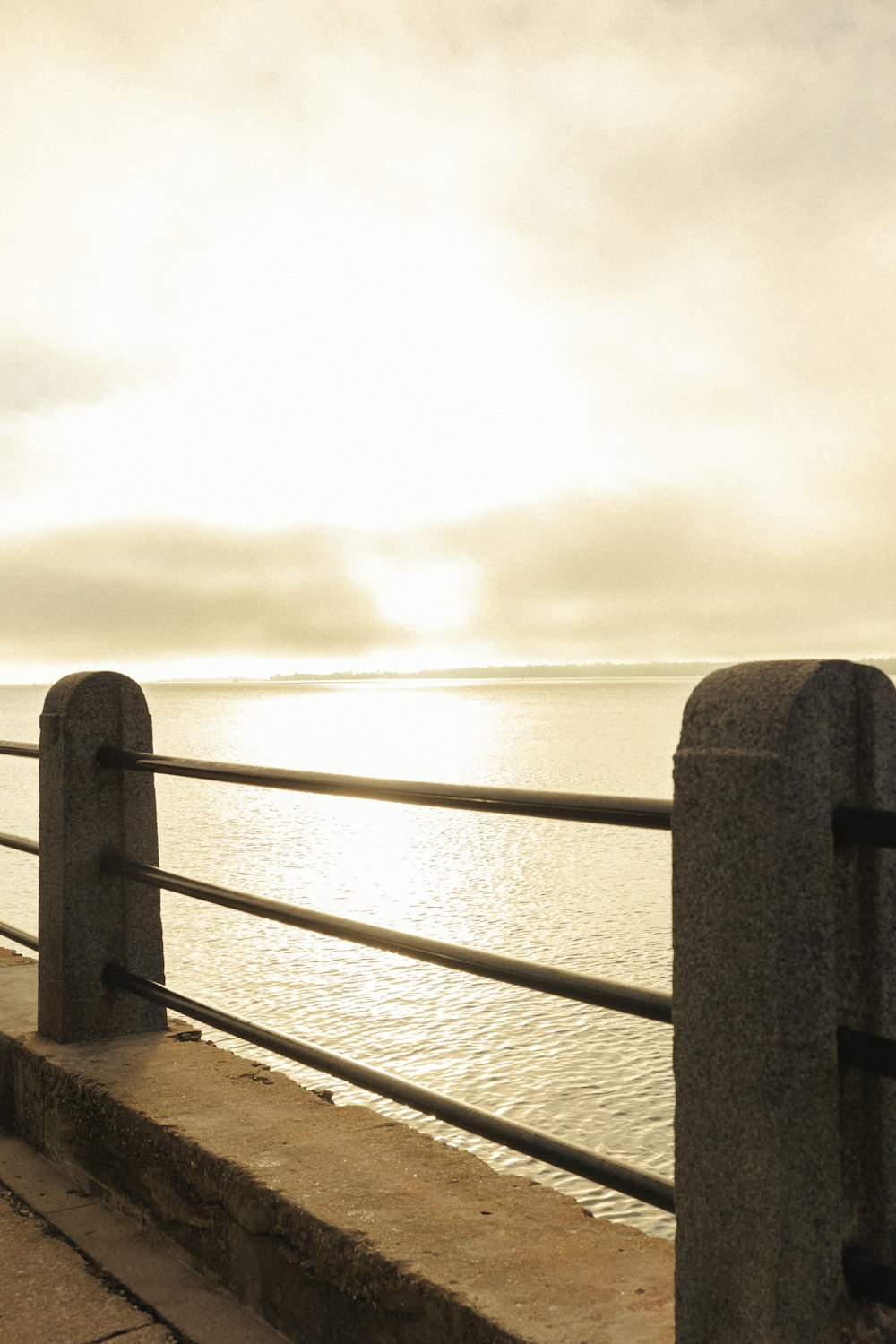 a man standing on a pier next to the ocean