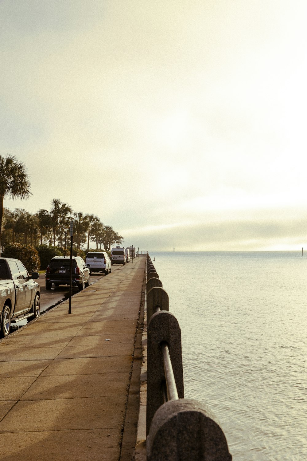 cars are parked along the side of the water