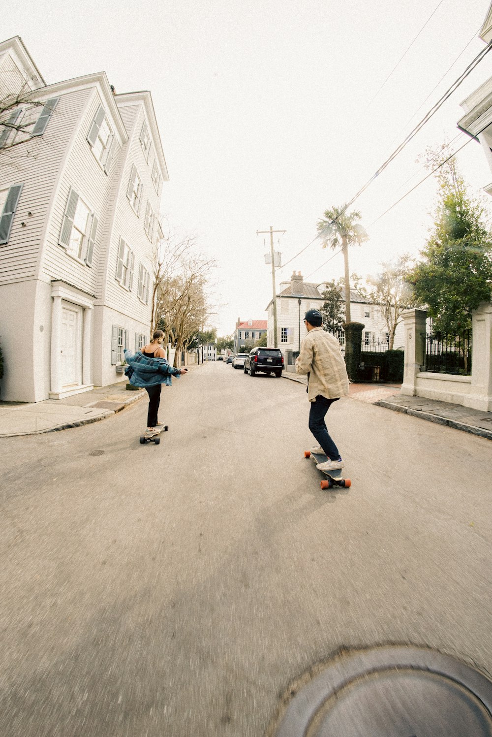 um casal de pessoas andando de skate por uma rua