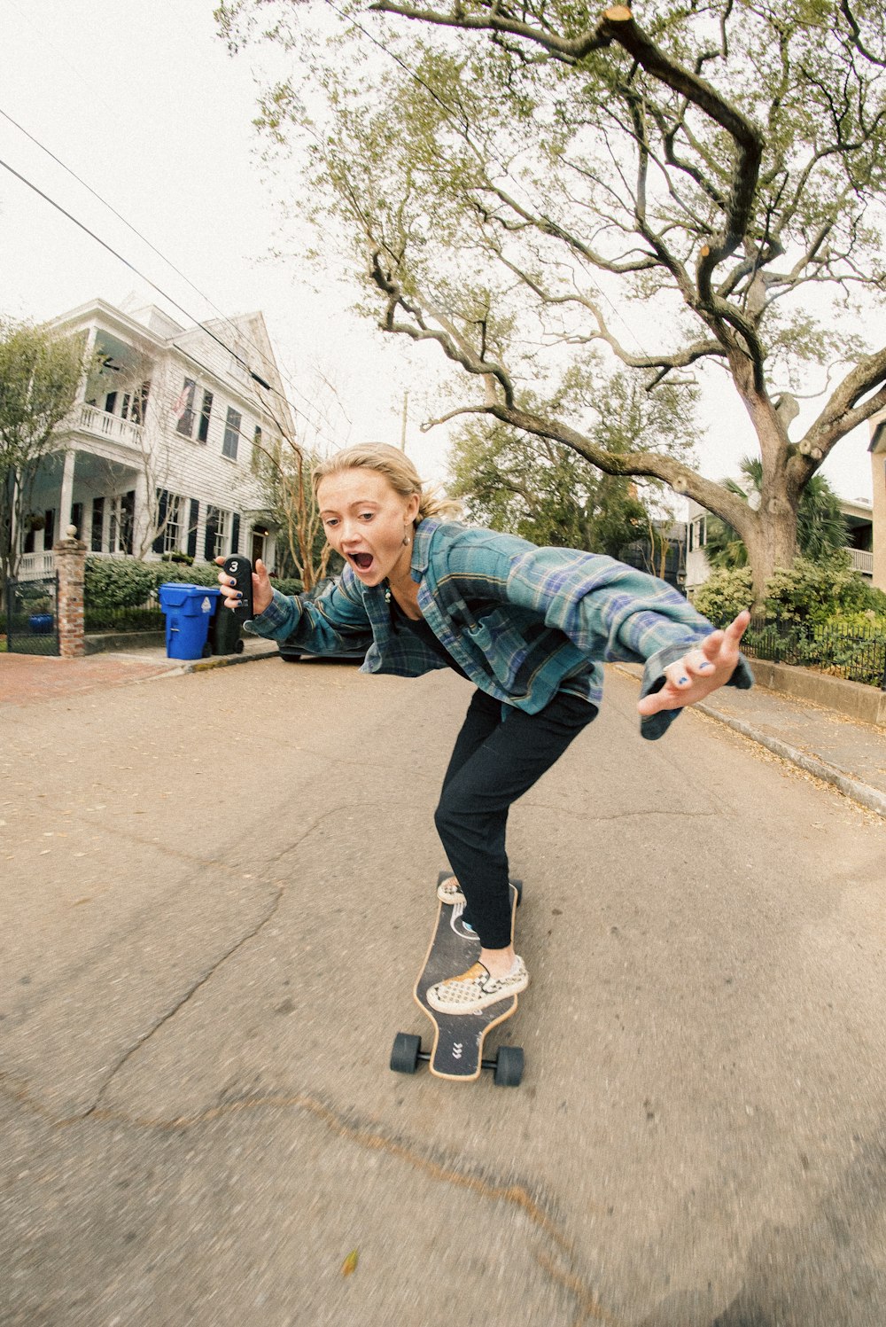 a woman riding a skateboard down a street