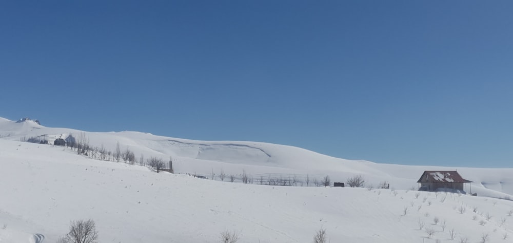a snow covered hill with a house on top of it
