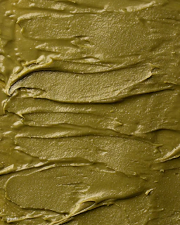 Snail mucin gel texture shown in a glossy swirl on a white ceramic dish