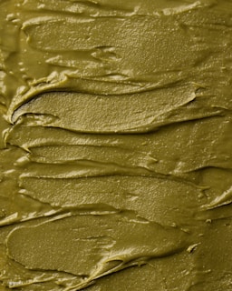 Close-up of vibrant, glossy slime in pastel pink swirls with glitter flecks catching the light.