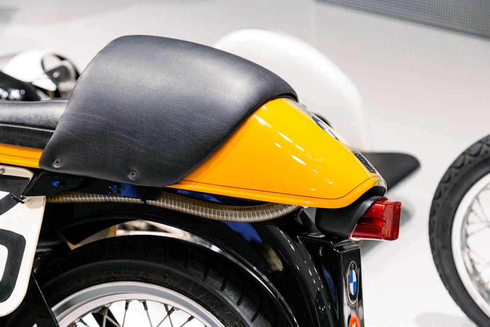 a close up of a yellow motorcycle with a black seat