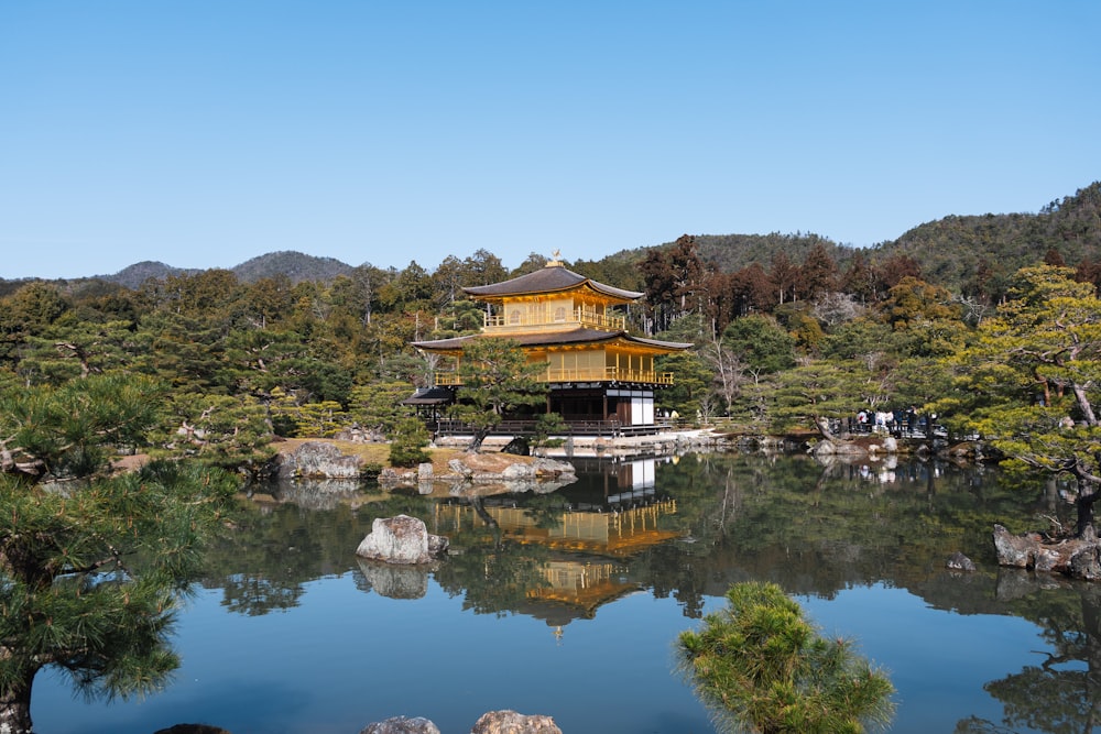 a small pond with a pagoda in the middle of it