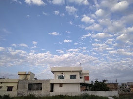 A beautiful residential property with lush greenery and a clear blue sky, representing ideal living spaces.