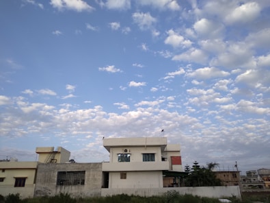 A beautiful residential property with lush greenery and a clear blue sky, representing ideal living spaces.