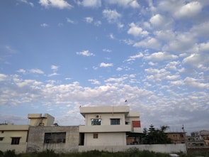 A newly completed cooperative residential building surrounded by greenery under a clear sky.