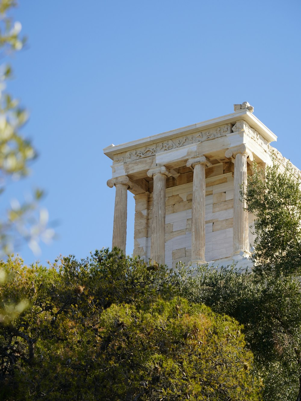 Un alto edificio blanco con columnas en la parte superior