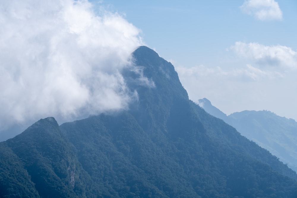 a very tall mountain with some clouds in the sky