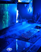 A sleek desktop setup featuring dual monitors showing custom app interfaces in green-gold tones.