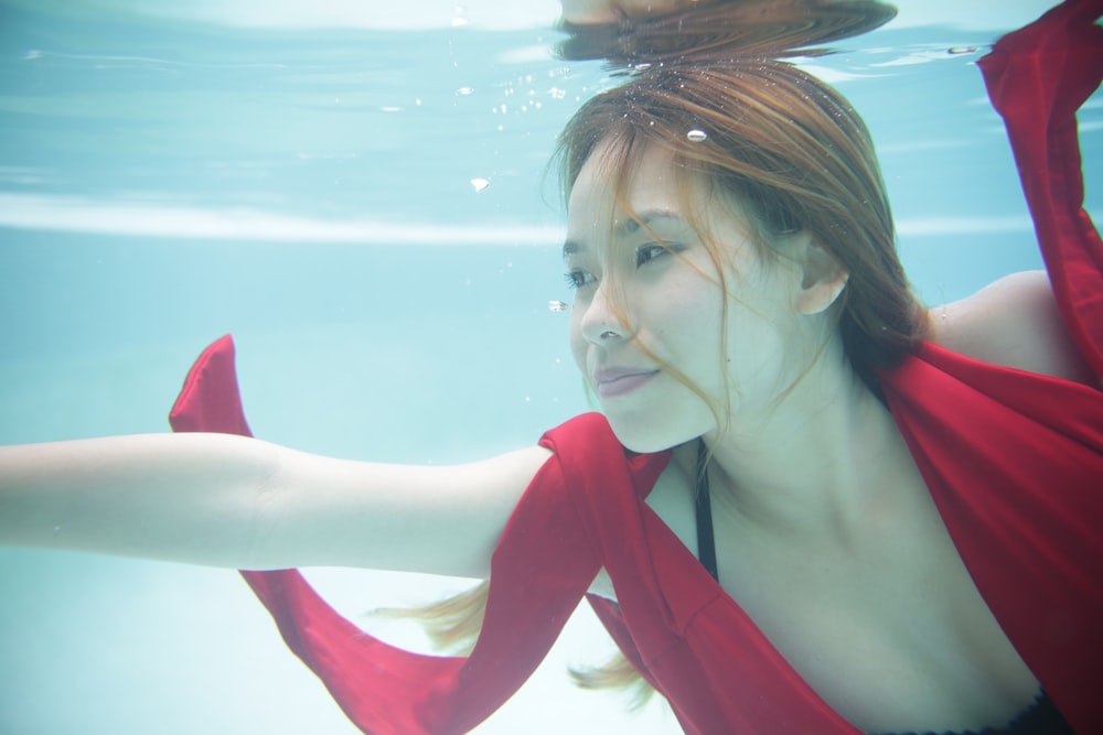 a woman in a red dress under water