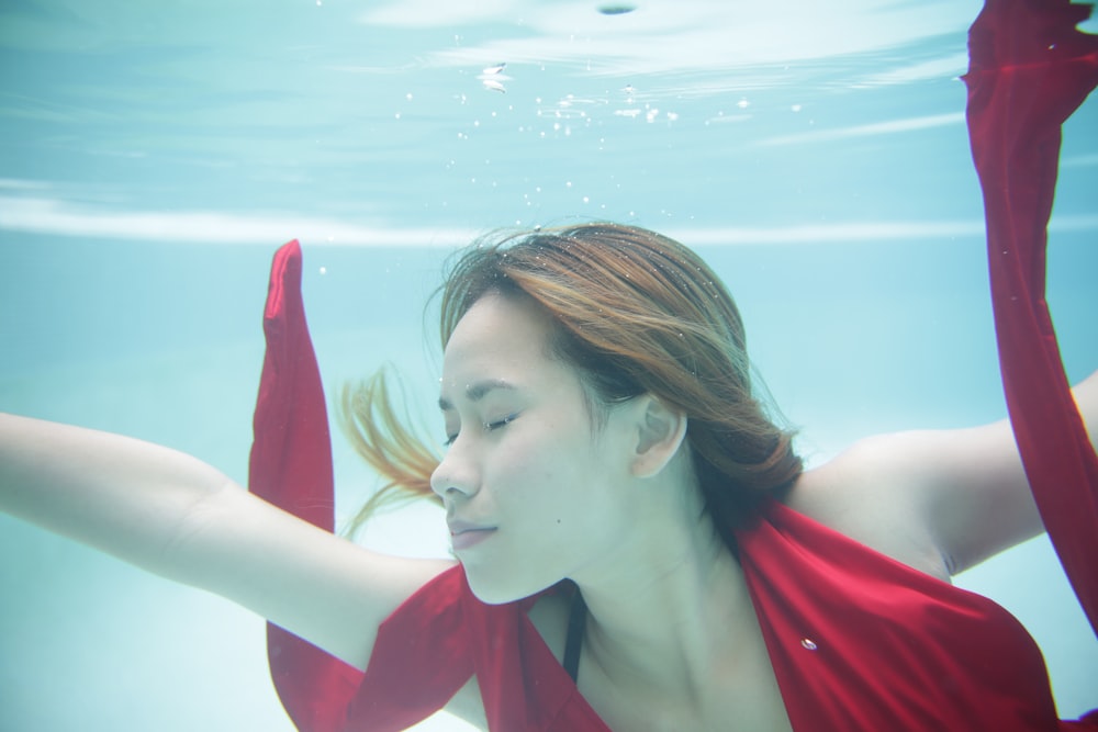 a woman in a red dress under water
