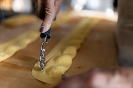 a person using a small tool to cut dough