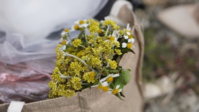 Close-up of a burlap-wrapped bouquet resting beside a lace-trimmed invitation card.