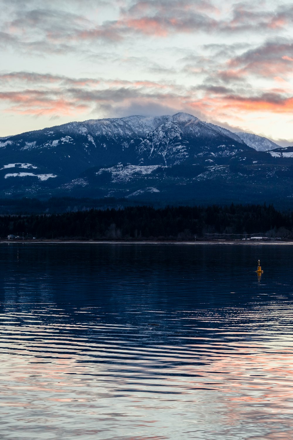 a large body of water with a mountain in the background