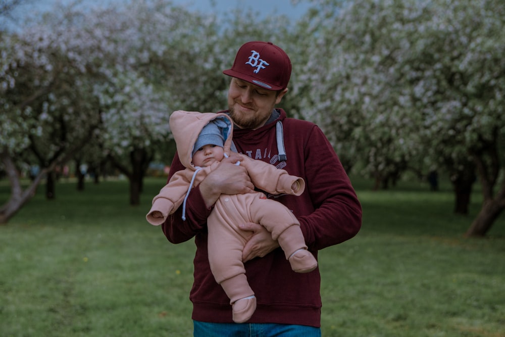 a man holding a baby in a park