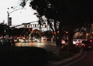 cars are driving down a busy street at night