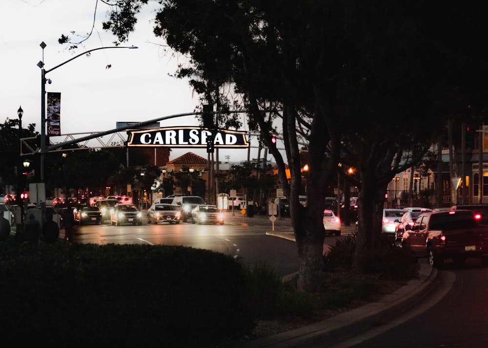 cars are driving down a busy street at night