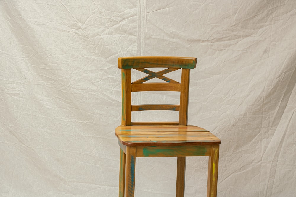 uma cadeira de madeira contra um pano de fundo branco