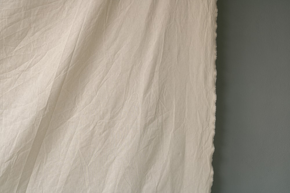 a close up of a white sheet on a bed