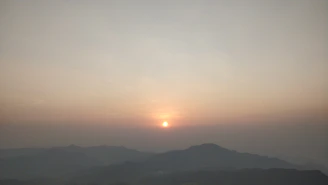A serene sunset casting warm light over a rugged mesa landscape.