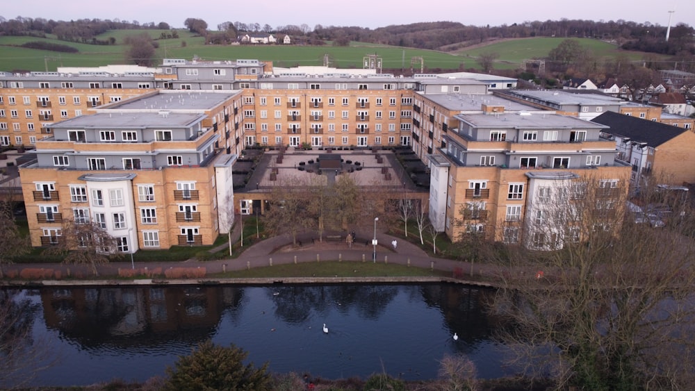 an aerial view of a building with a pond in front of it