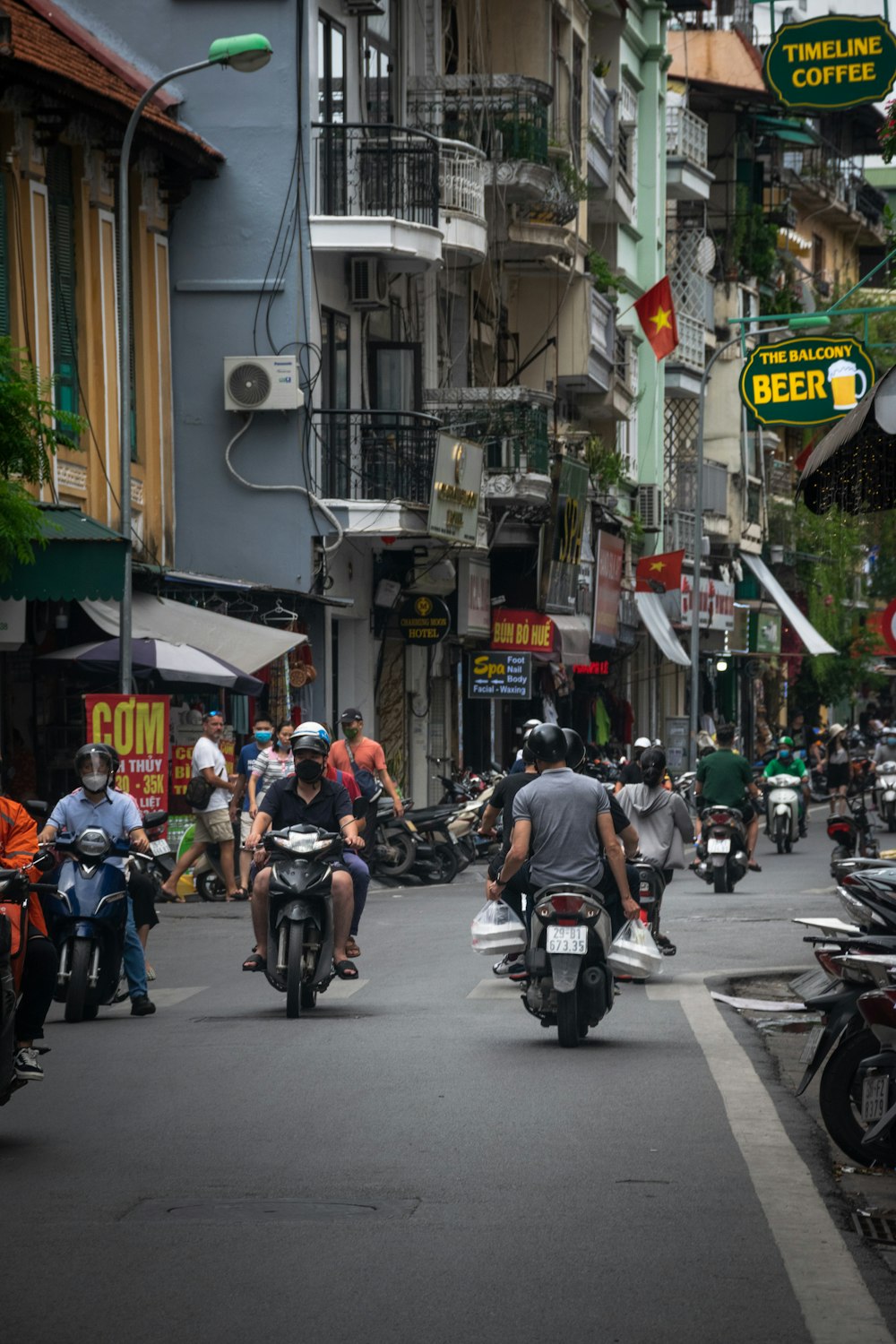 a group of people riding motorcycles down a street