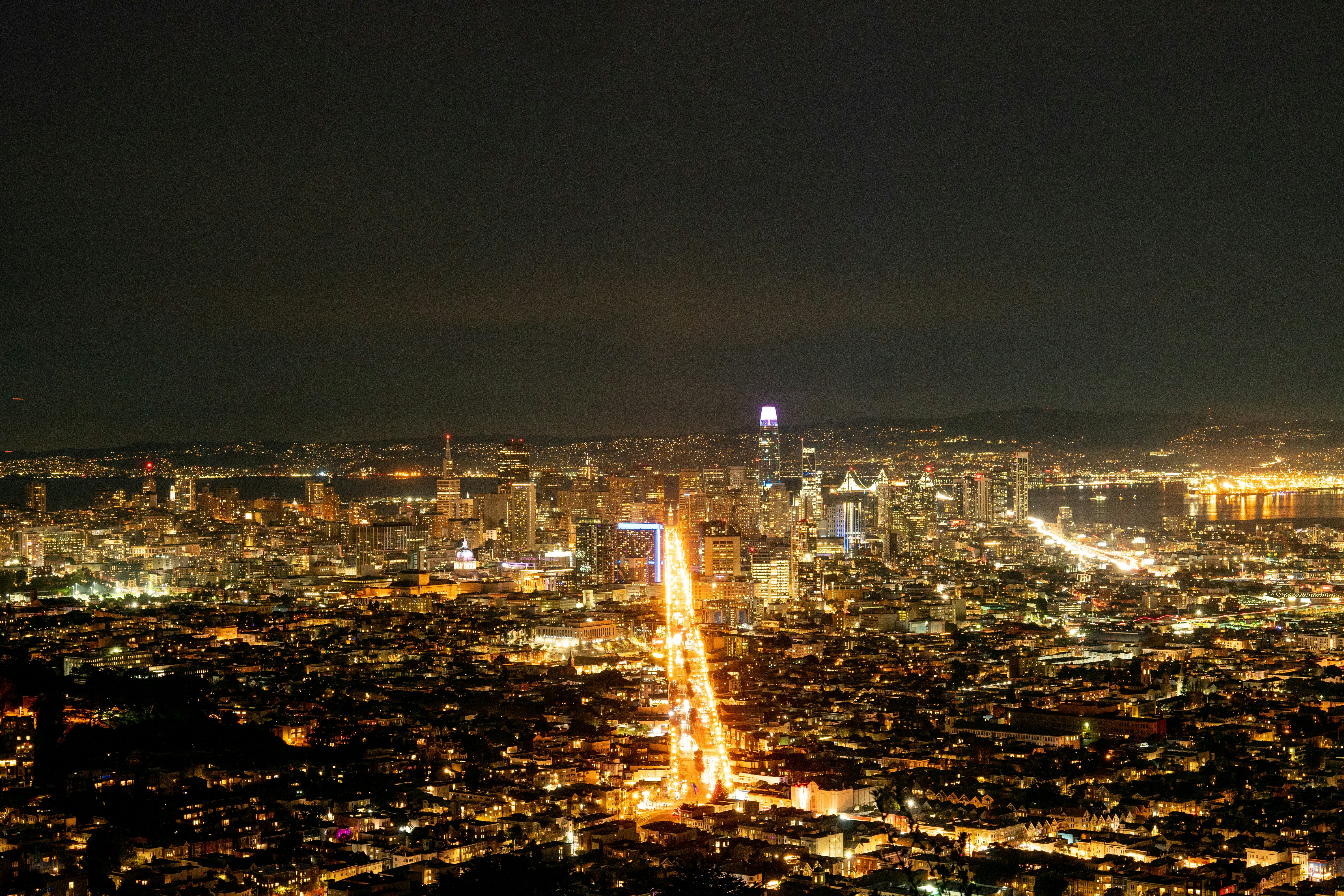 a view of a city at night from the top of a hill