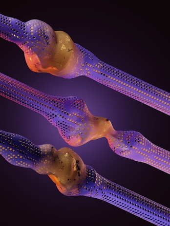 Intricate structures resembling nanofibers or cellular formations are depicted with a blend of purple and gold hues. The surfaces are perforated with numerous small holes, creating an intricate, organic appearance. The background is a smooth gradient of dark purples, enhancing the vibrant colors of the main elements.