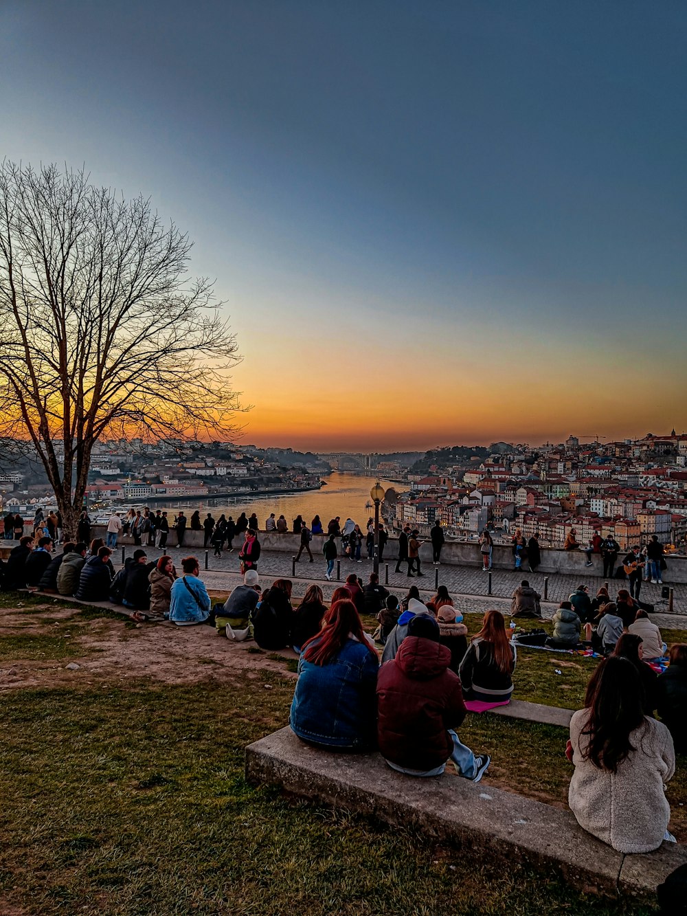 a group of people sitting on top of a stone bench