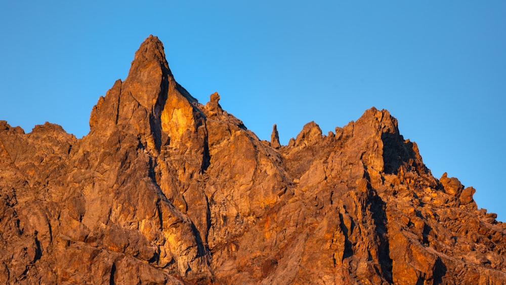 a very tall mountain with a blue sky in the background