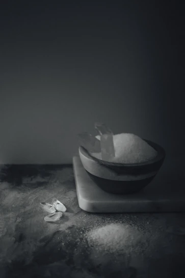 Heap of coarse caustic soda flakes arranged on a rustic wooden surface