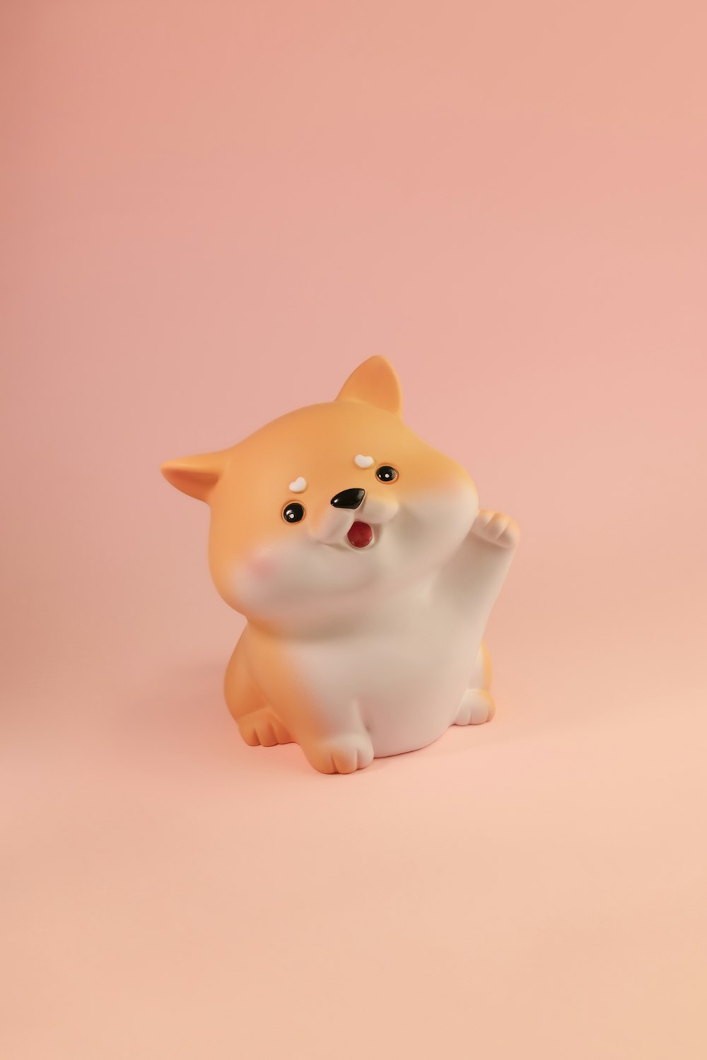 a small figurine of a dog on a pink background