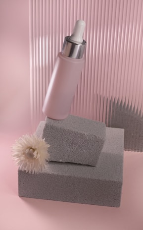 Artistic composition of dr. lady’s signature products surrounded by delicate flowers in nude and blush hues.