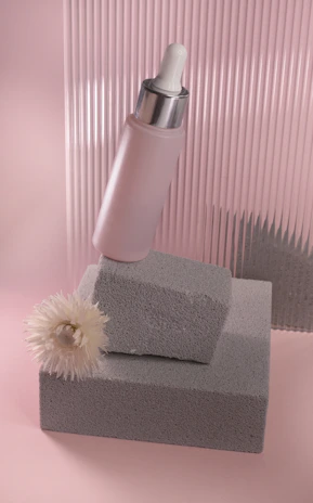 Elegant pink cream jar of Aurora Pink on a soft beige background with gentle lighting.