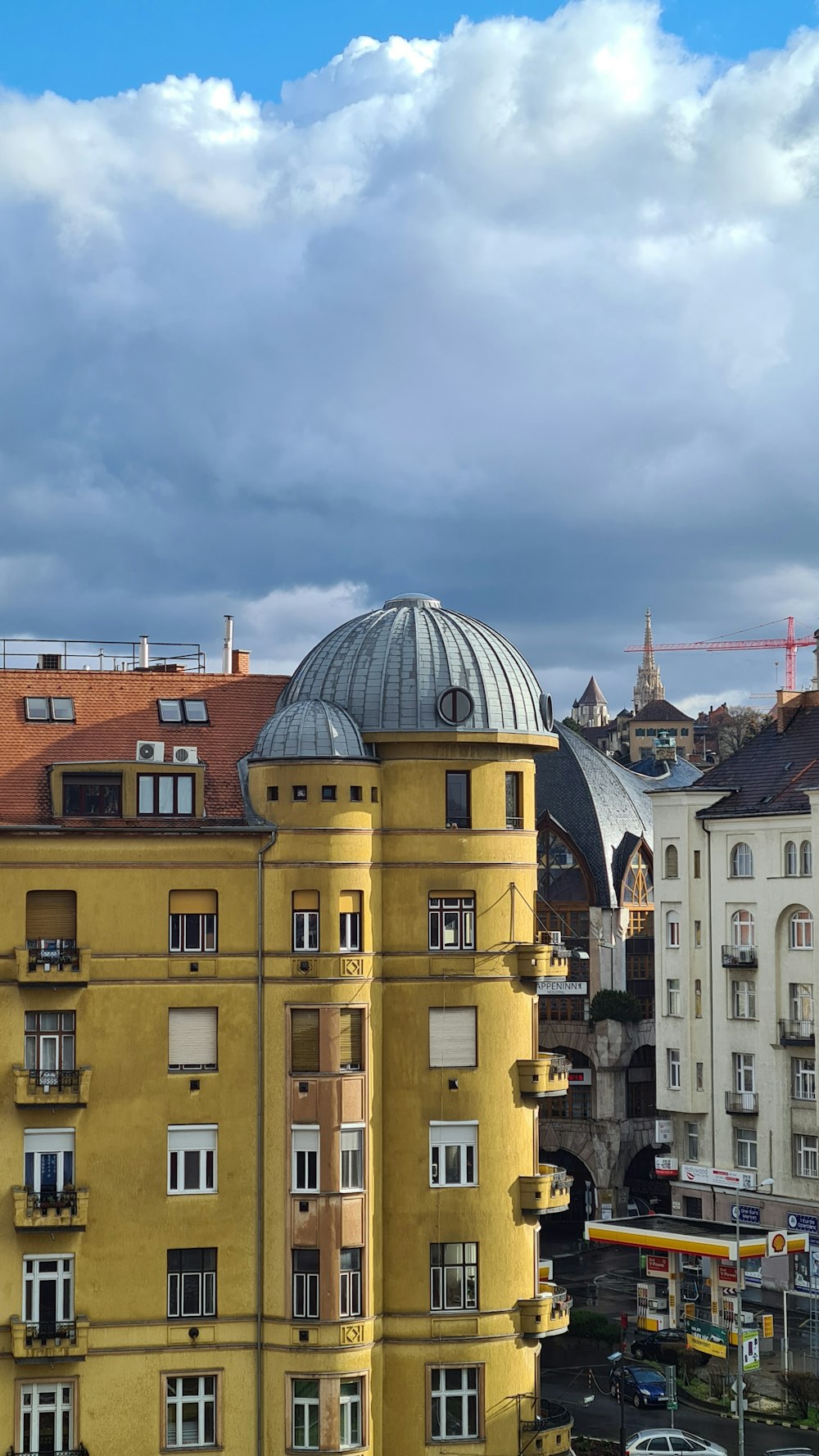 a tall yellow building with a dome on top of it