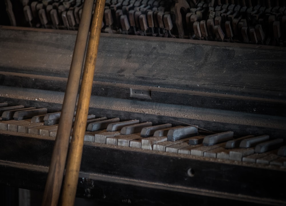 a close up of a piano with a wooden stick