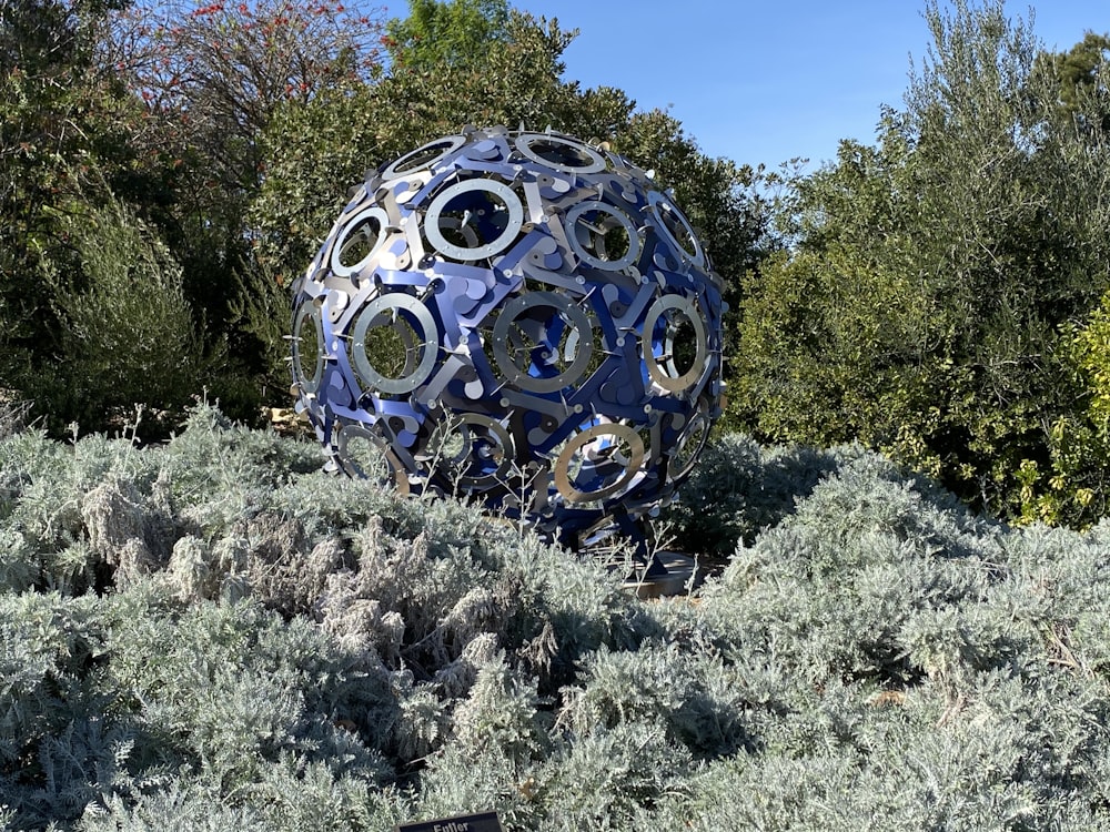 a large metal ball sitting in the middle of a field