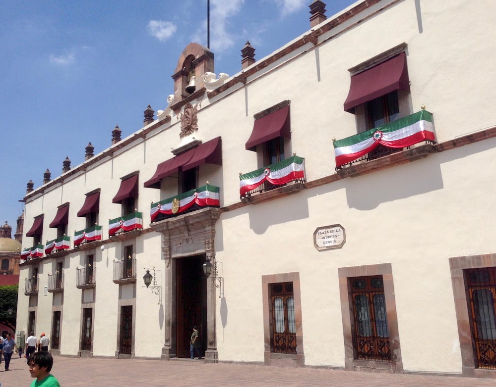 a white building with red, white and green awnings