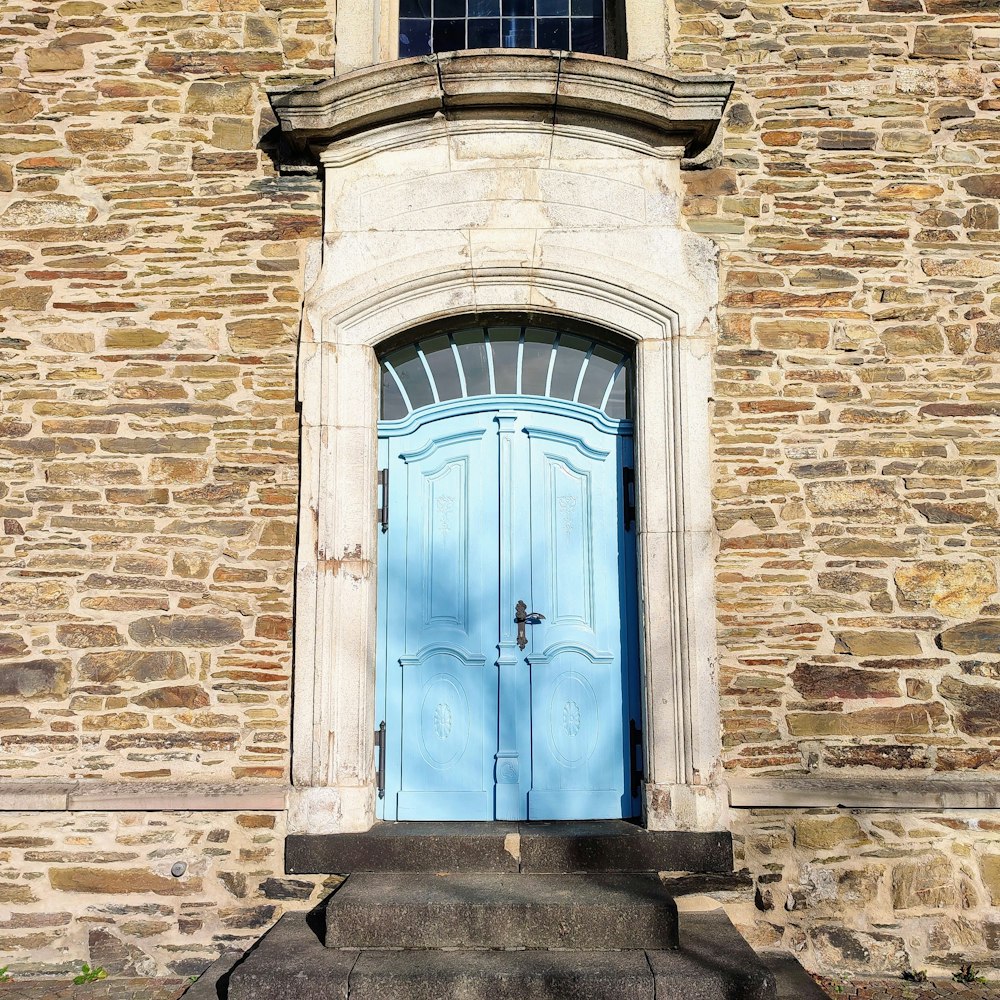 a stone building with a blue door and window