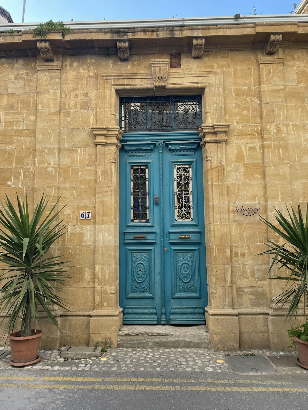 a building with a blue door and two potted plants