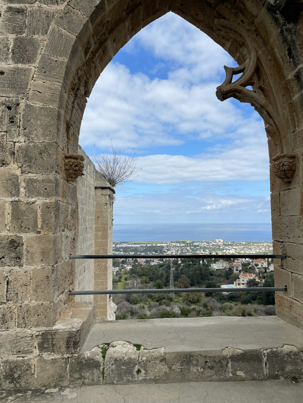 a stone arch with a view of a city