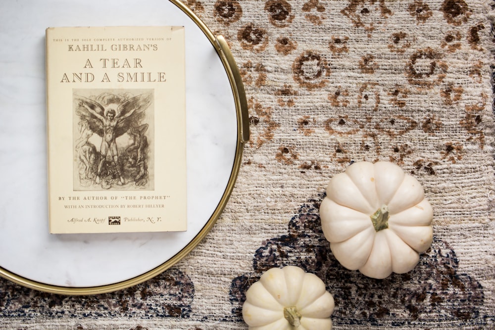 a book sitting on top of a table next to a pumpkin