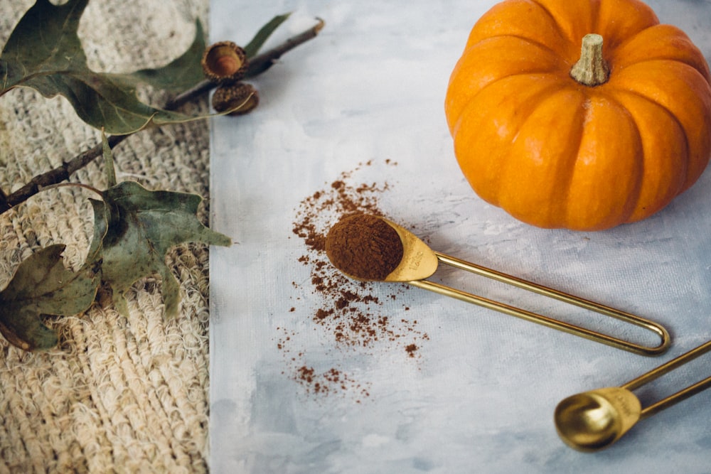 a table topped with spices and a pumpkin