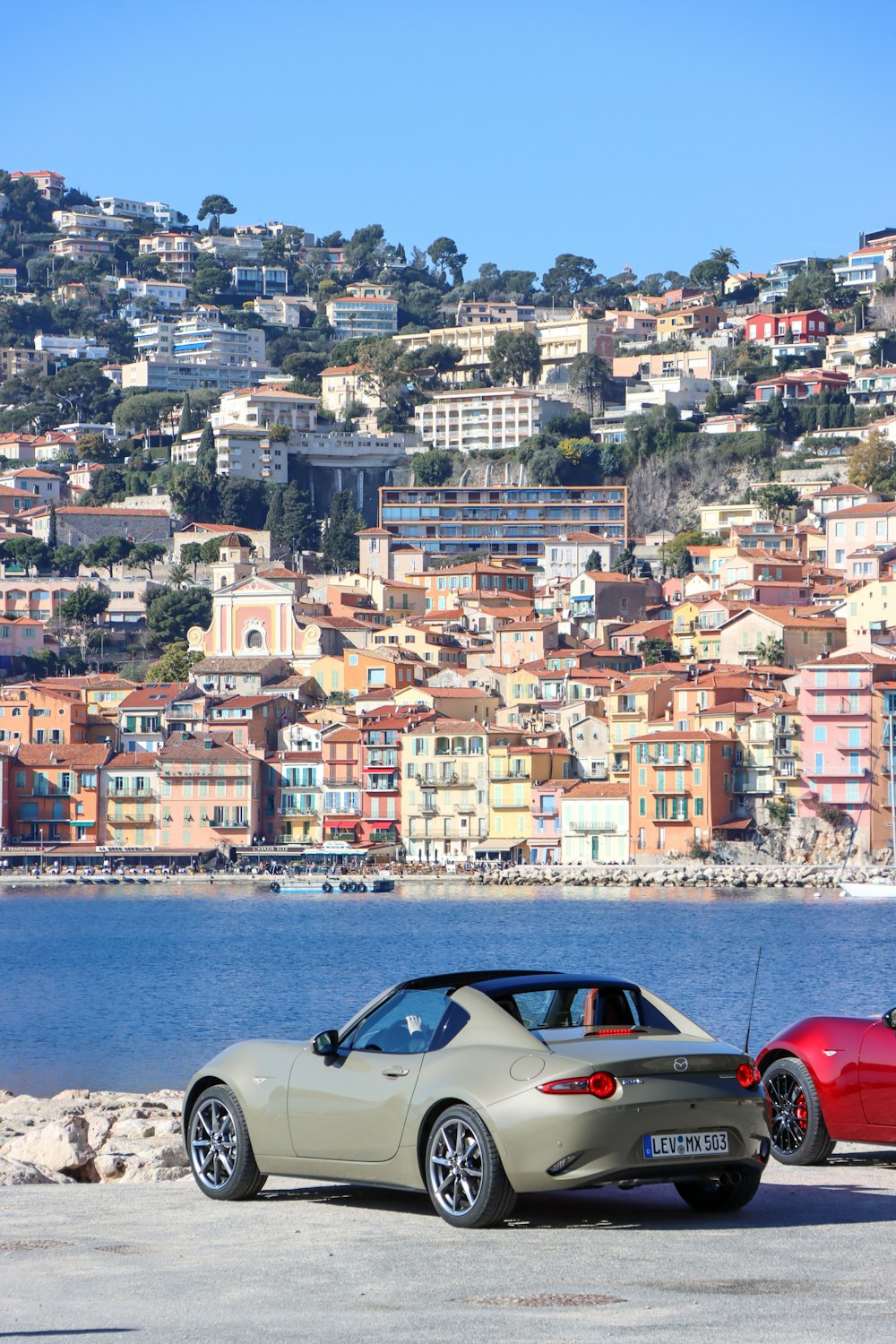 two cars parked next to each other near a body of water