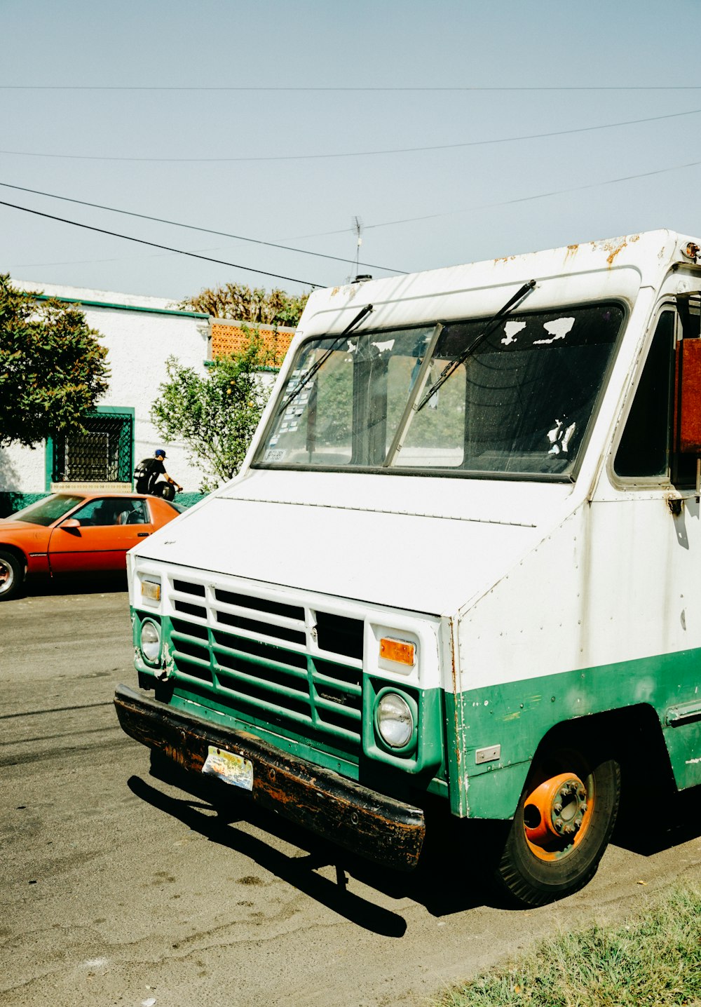 a green and white truck parked on the side of the road